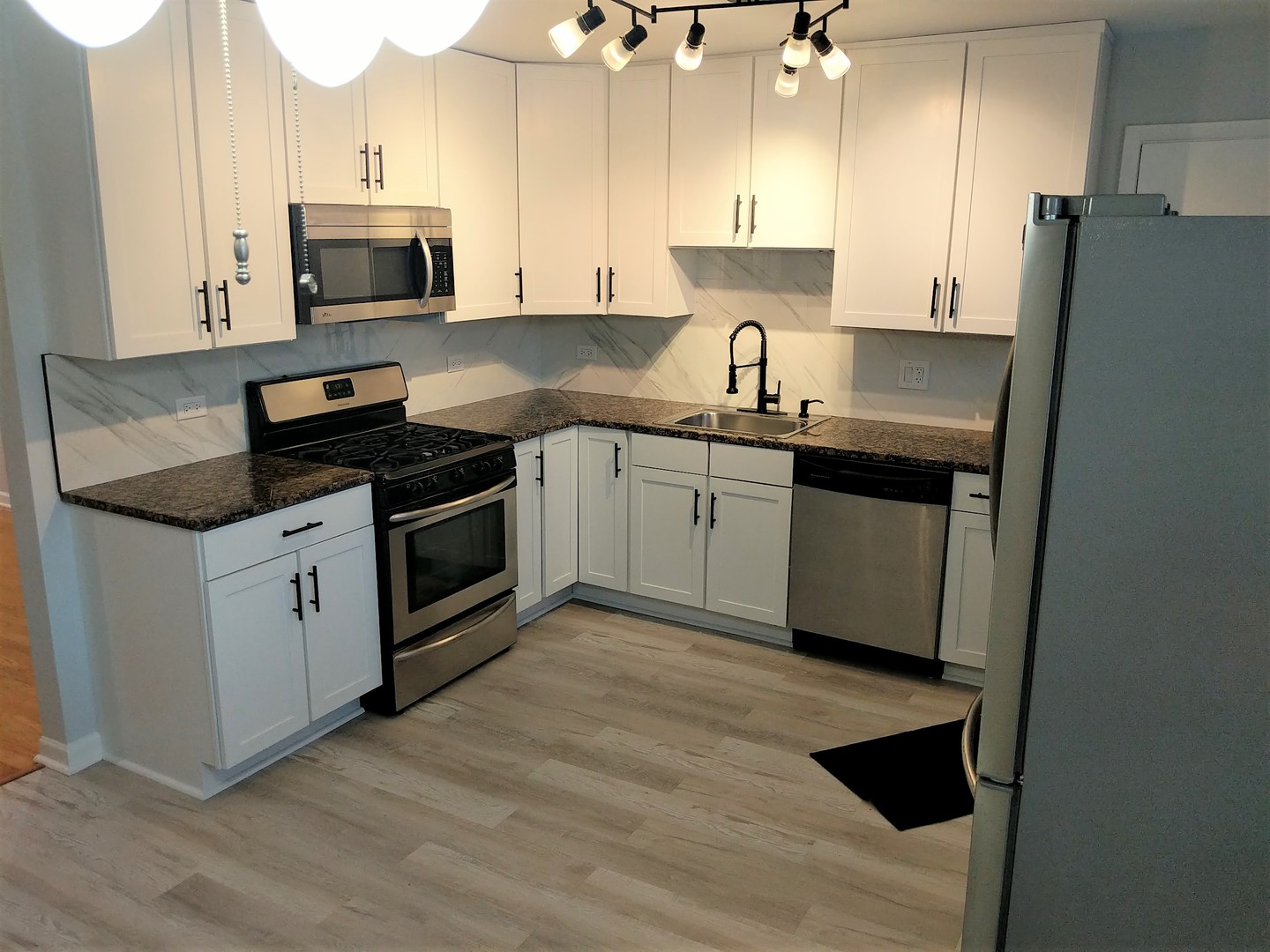 2652 West Rascher Avenue, Unit 203 Chicago, IL 60625 - Photo 2 of 17 a kitchen with granite countertop a sink stove and refrigerator