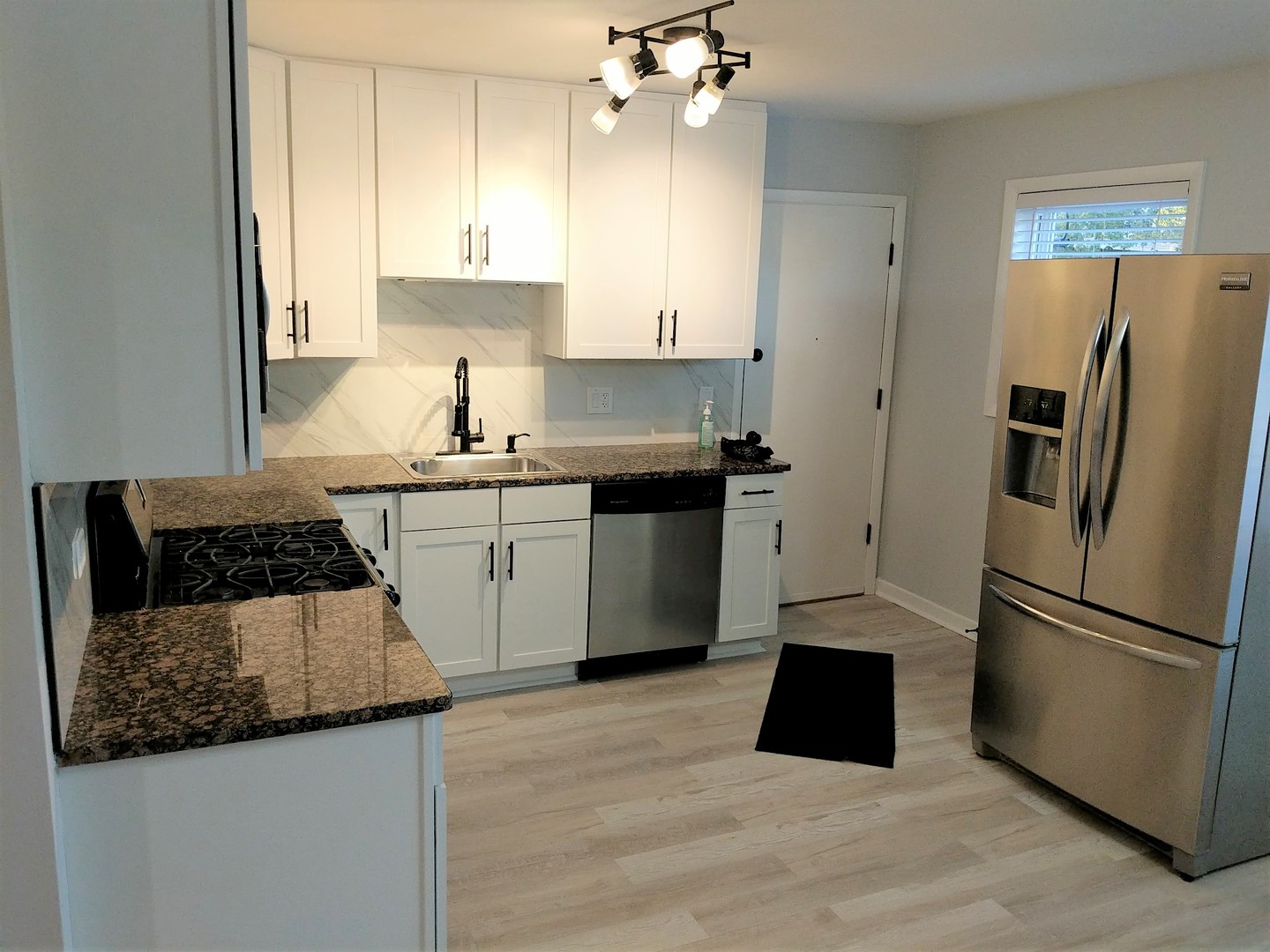2652 West Rascher Avenue, Unit 203 Chicago, IL 60625 - Photo 3 of 17 a kitchen with a sink dishwasher a refrigerator a stove and white cabinets with wooden floor