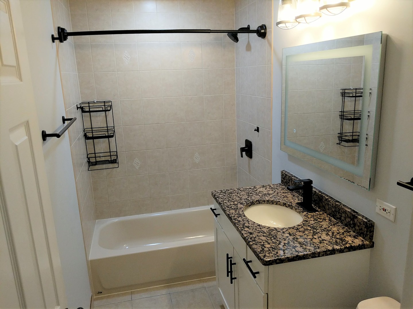 2652 West Rascher Avenue, Unit 203 Chicago, IL 60625 - Photo 5 of 17 a bathroom with a granite countertop sink shower and a mirror