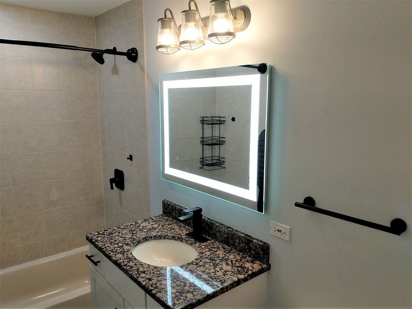 2652 West Rascher Avenue, Unit 203 Chicago, IL 60625 - Photo 6 of 17 a bathroom with a granite countertop sink mirror and a bathtub