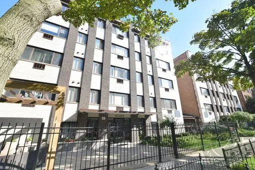 a front view of a building with a garden