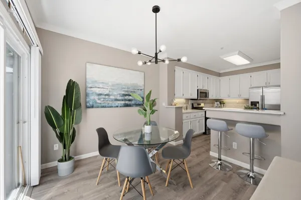a dining room with furniture potted plants and wooden floor