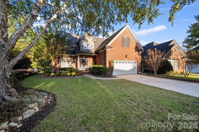 a front view of a house with a yard and trees