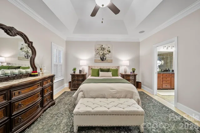 a bedroom with a large bed and a chandelier