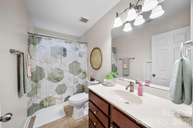 a bathroom with a granite countertop sink mirror vanity and toilet