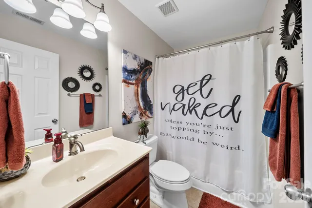 a bathroom with a sink vanity mirror and toilet