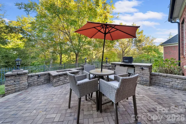 a view of patio with chairs and table under an umbrella