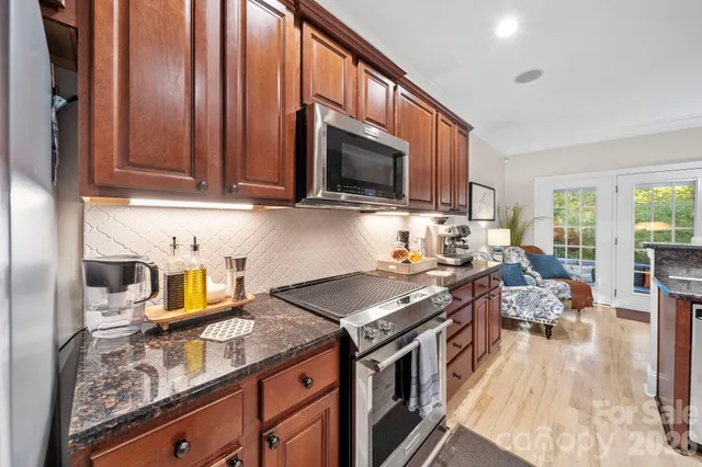 a kitchen with stainless steel appliances granite countertop a stove a sink and a microwave