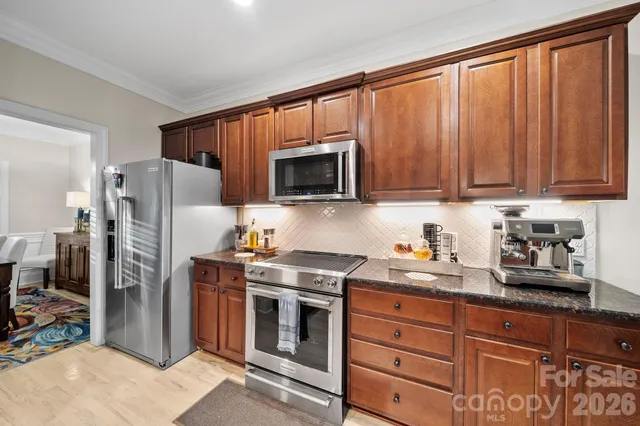 a kitchen with stainless steel appliances granite countertop a refrigerator stove and microwave
