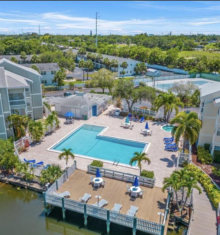 6932 Stonesthrow Circle North, Unit 7204 St. Petersburg, FL 33710 - Photo 22 of 27 a view of a swimming pool with a patio and a yard