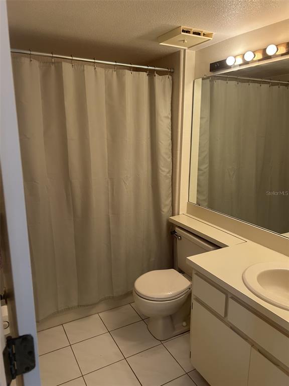 6932 Stonesthrow Circle North, Unit 7204 St. Petersburg, FL 33710 - Photo 6 of 27 a bathroom with a sink a toilet a mirror and shower curtain