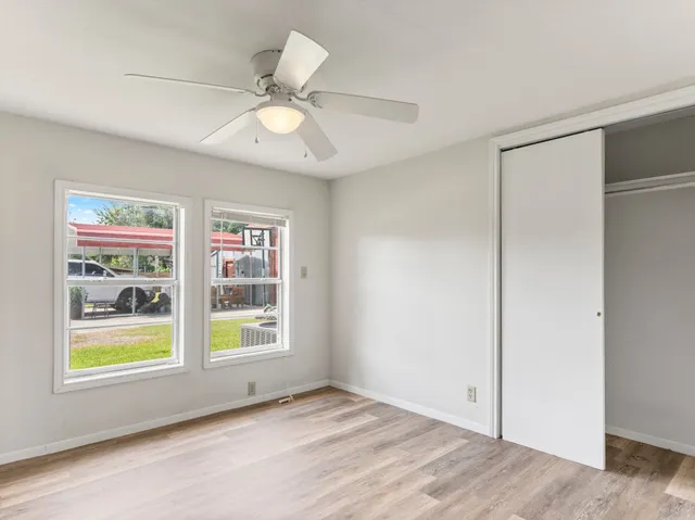 a view of an empty room with a window and closet
