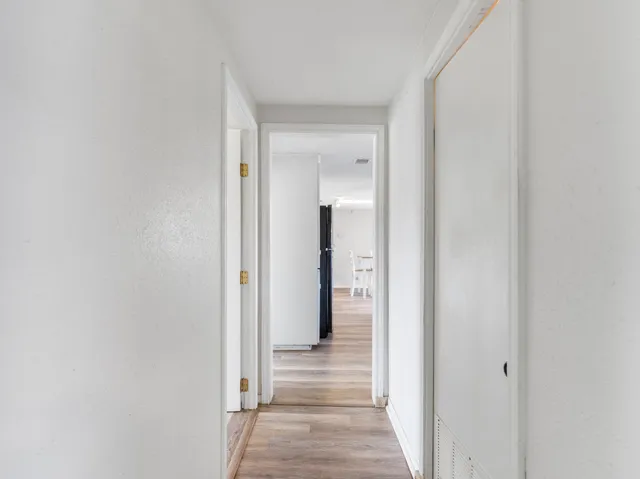 a view of a hallway with wooden floor
