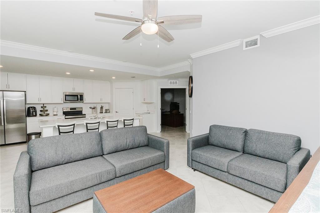 6082 National Blvd Avenue, Unit 115 Immokalee, FL 34142 - Photo 11 of 50 a living room with furniture white cabinets and couches with kitchen view