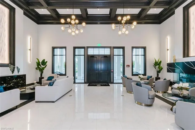 a living room with furniture flowers and wooden floor