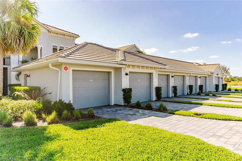 6082 National Blvd Avenue, Unit 115 Immokalee, FL 34142 - Photo 4 of 50 a front view of a house with a yard and potted plants