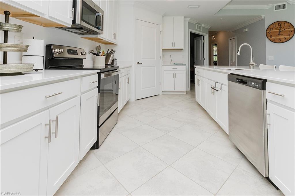 6082 National Blvd Avenue, Unit 115 Immokalee, FL 34142 - Photo 7 of 50 a kitchen with stainless steel appliances a stove microwave and sink