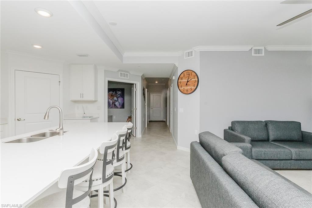 6082 National Blvd Avenue, Unit 115 Immokalee, FL 34142 - Photo 10 of 50 a living room with furniture a clock and a wooden floor