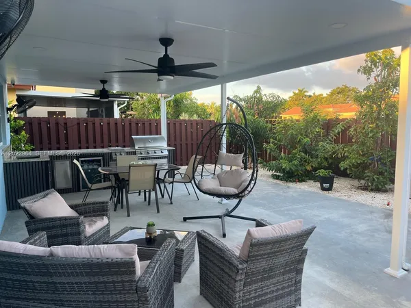 a living room with patio furniture and a potted plant