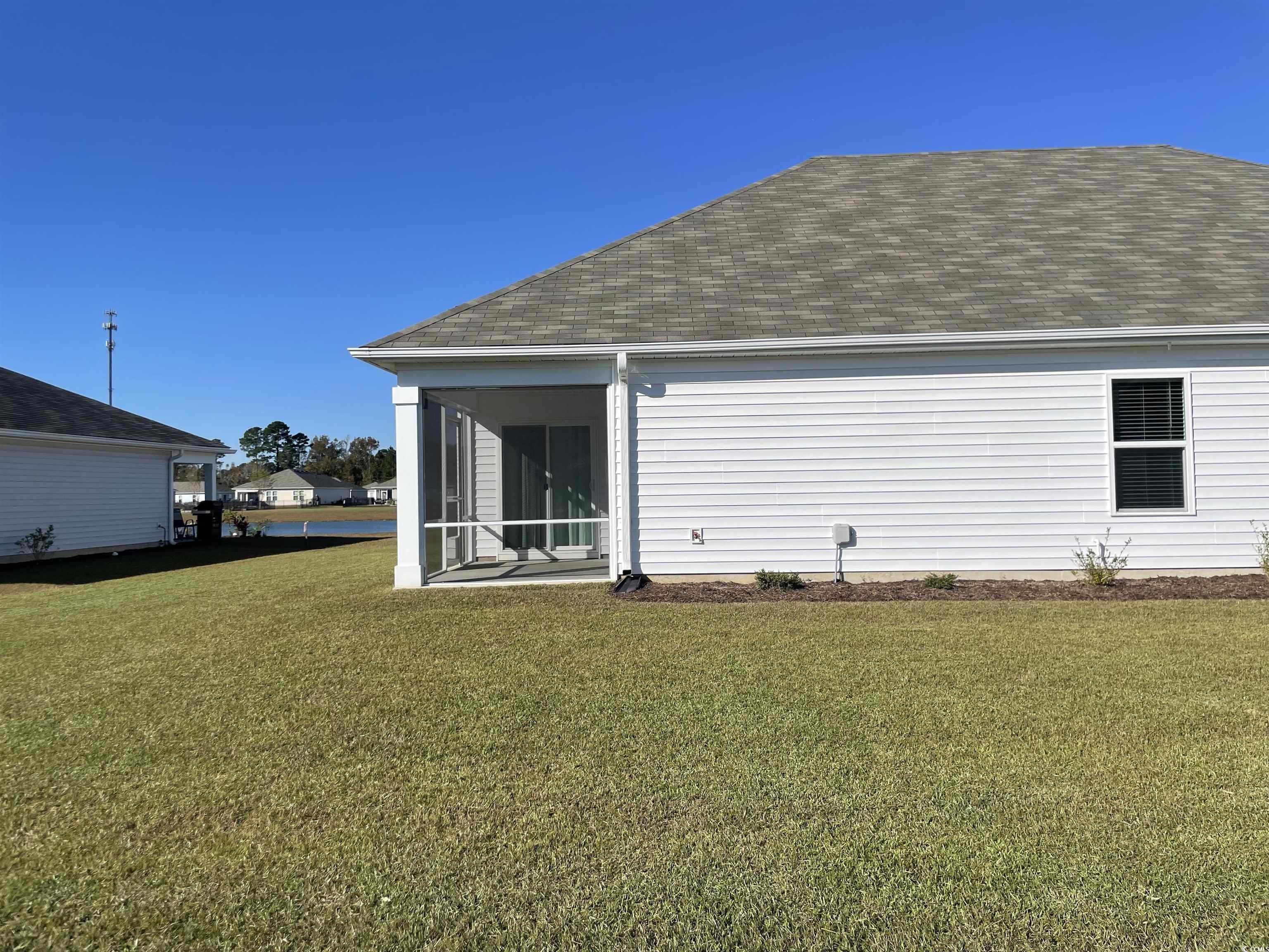 351 Jeff Waters Circle Longs, SC 29568 - Photo 31 of 33 Rear view of house with a sunroom, a shingled roof, and a lawn