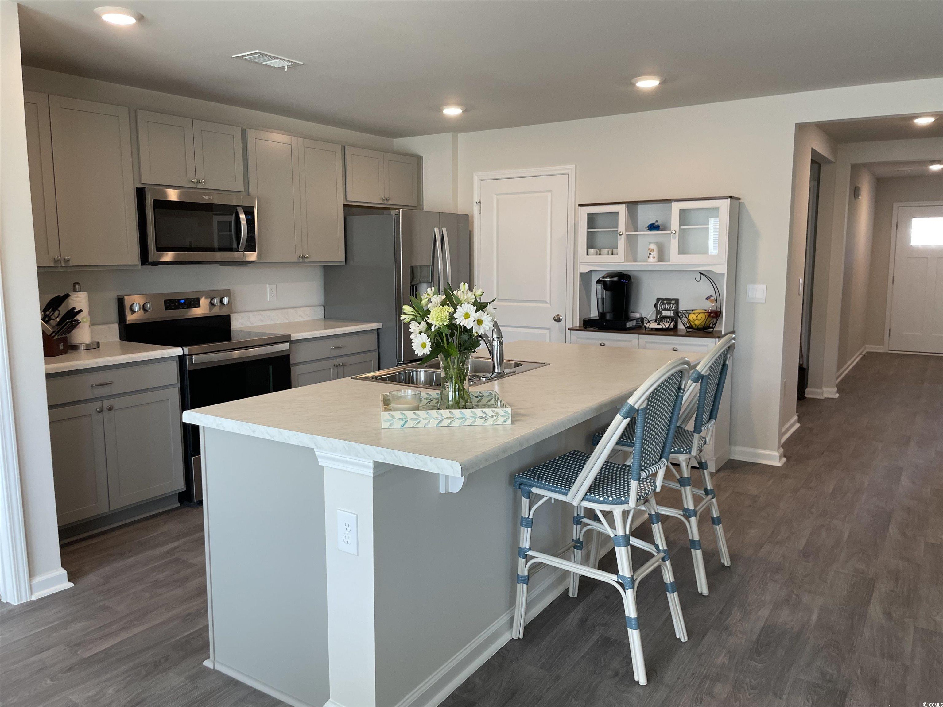 351 Jeff Waters Circle Longs, SC 29568 - Photo 9 of 33 Kitchen featuring stainless steel appliances, gray cabinets, a kitchen breakfast bar, recessed lighting, and light countertops