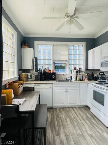 a kitchen with a dining table chairs cabinets a sink and appliances