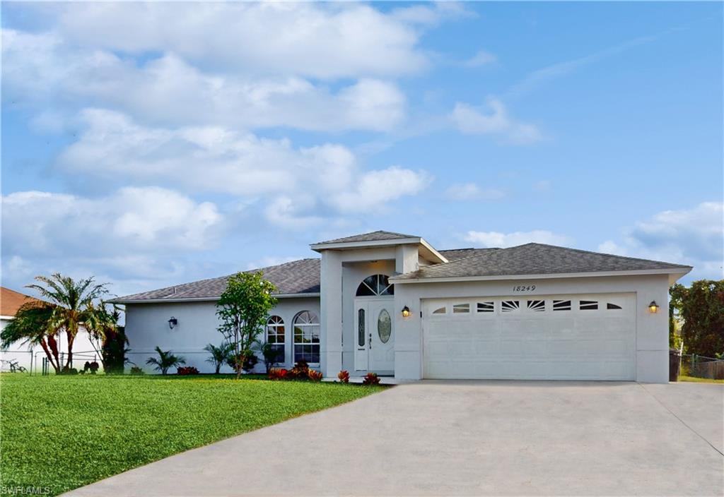18249 Lee Road Fort Myers, FL 33967 - Photo 1 of 31 a front view of a house with a garden and garage