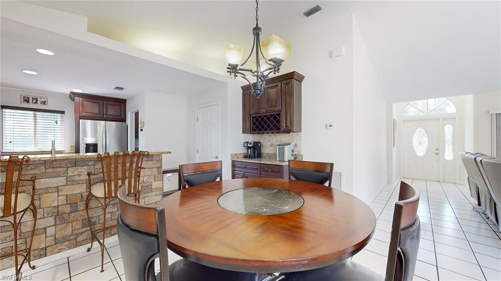 18249 Lee Road Fort Myers, FL 33967 - Photo 9 of 31 a dining room with furniture a window and a chandelier