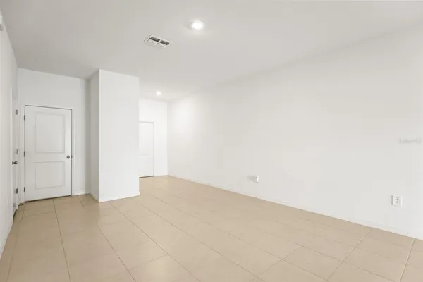 a kitchen with stainless steel appliances kitchen island granite countertop a dining table chairs and a refrigerator