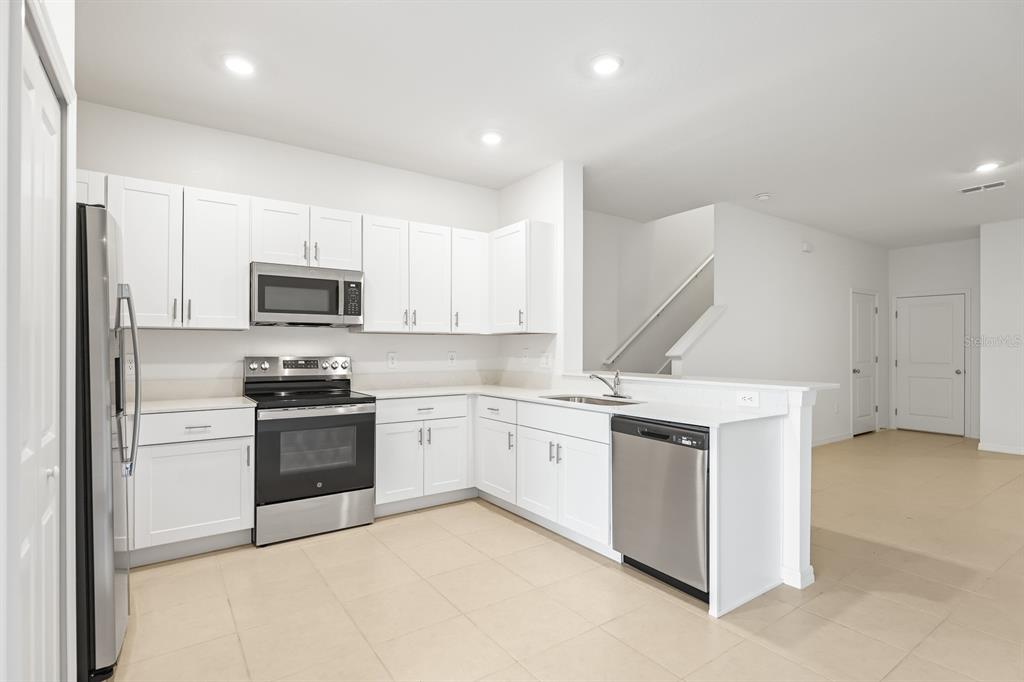 2642 Sunray Venus Way Ruskin, FL 33570 - Photo 10 of 30 a kitchen with a stove and a microwave