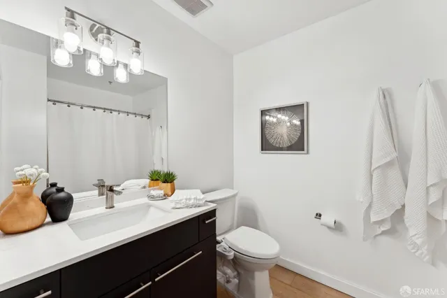 a bathroom with a sink a toilet and mirror