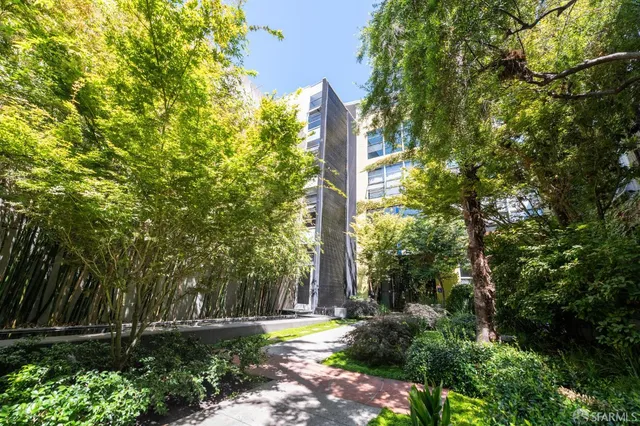 a sign that is sitting in front of a tree