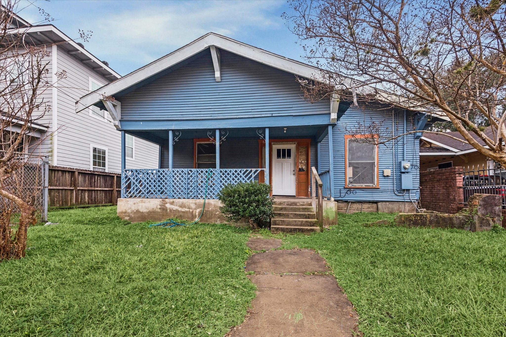 a front view of a house with a yard and fence