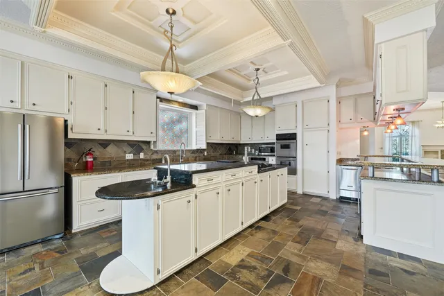 a kitchen with stainless steel appliances granite countertop a sink a stove and refrigerator
