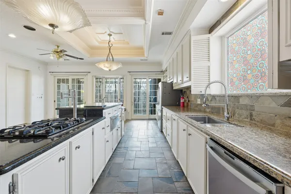 a large kitchen with stainless steel appliances granite countertop a lot of counter space and a large window