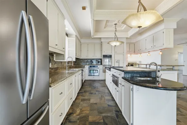 a kitchen with stainless steel appliances granite countertop a sink a stove and a refrigerator