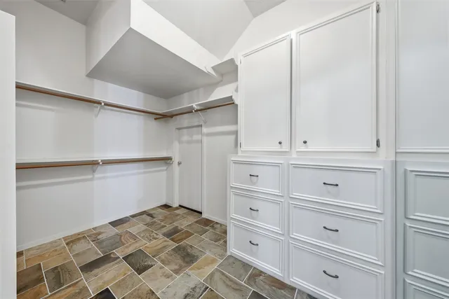 a spacious bathroom with a granite countertop double vanity sink a mirror and a shower