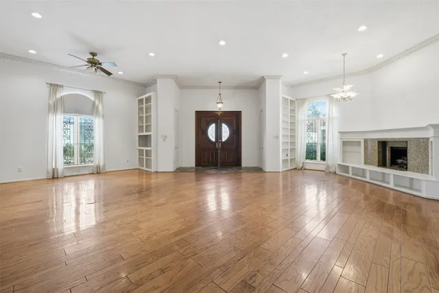 an empty room with wooden floor and chandelier
