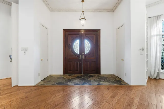 a view of a room with wooden floor and a ceiling fan