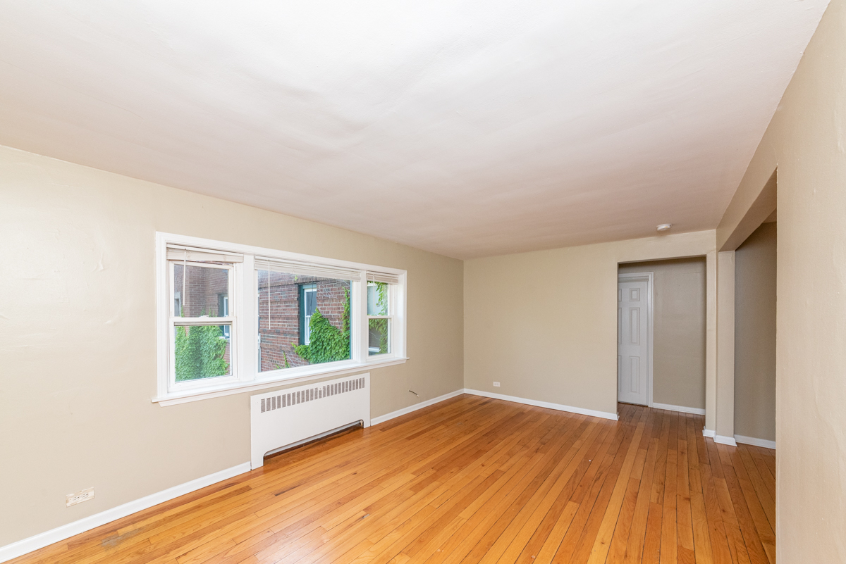 233 Custer Avenue, Unit 3 Evanston, IL 60202 - Photo 12 of 13 a view of an empty room with wooden floor and a window