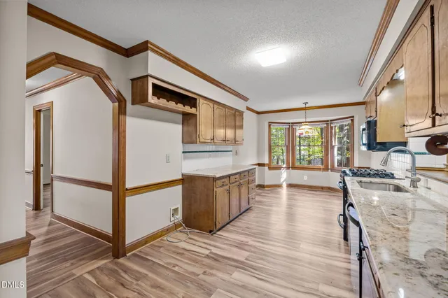 a kitchen with granite countertop a stove a sink and a refrigerator
