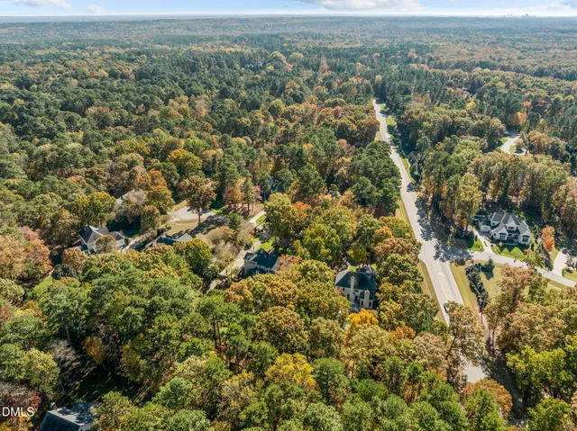 a view of a lake with a yard and large trees