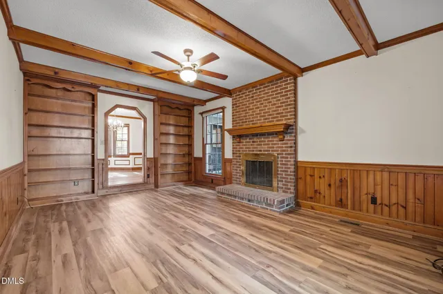a view of empty room with wooden floor and fireplace