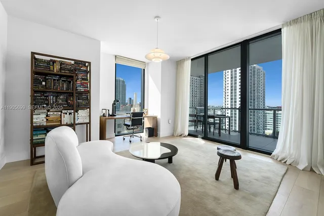 a living room with furniture and a floor to ceiling window