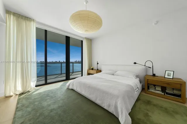 a spacious bedroom with a bed and a chandelier