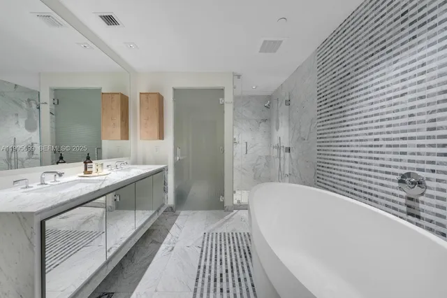 a spacious bathroom with a tub sink and mirror