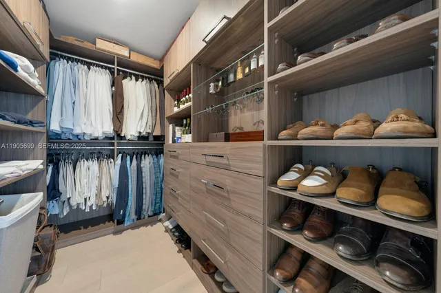 a view of walk in closet with clothes and shoes
