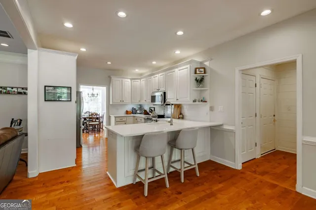 a kitchen with white cabinets and appliances
