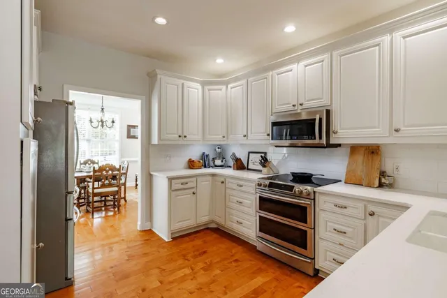 a kitchen with stainless steel appliances granite countertop a stove a sink and a refrigerator
