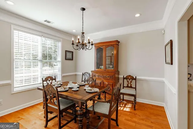 a view of a dining room with furniture a chandelier and wooden floor